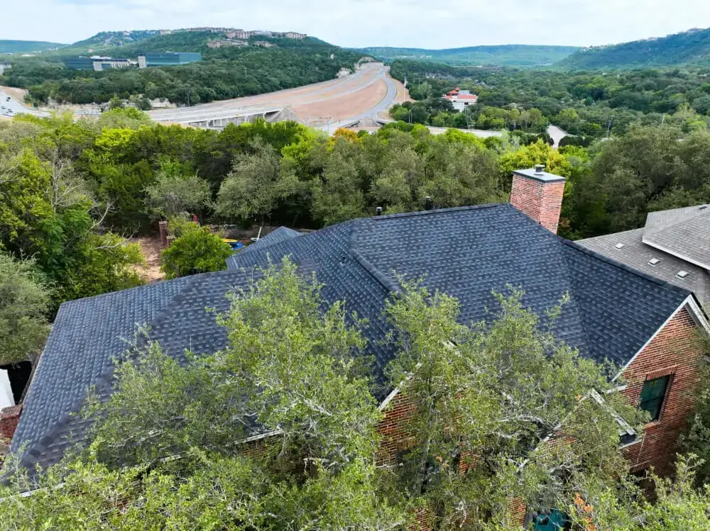 An aerial view of a residential home in Texas with a new shingle roof installed by Texas Roof Repair.