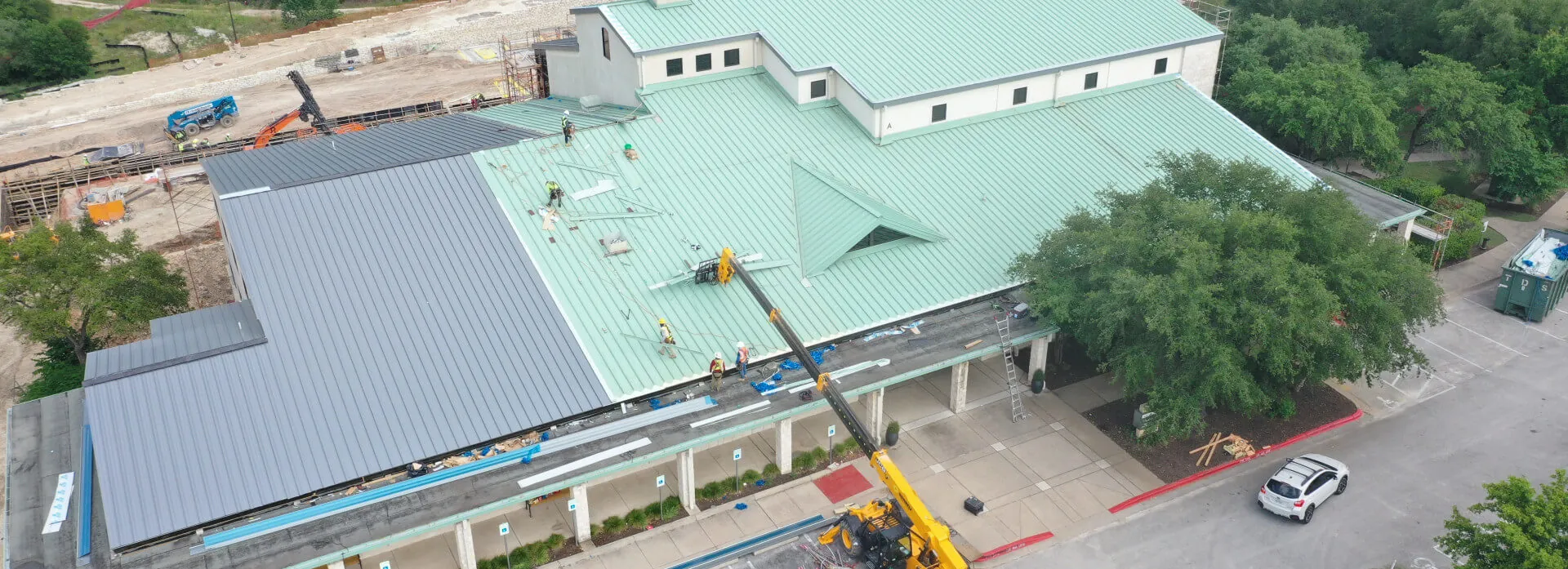 A Texas Roof Repair crew on a large commercial building installing a new metal roof.